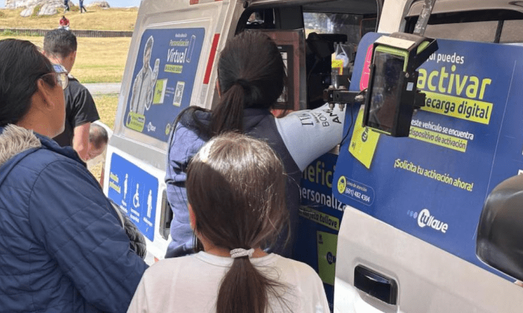 Imagen de personas al frente de una van recargando la tarjeta TuLlave