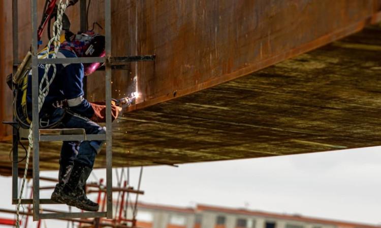 Foto de obreros realizando trabajos en un puente vehicular en Bogotá.