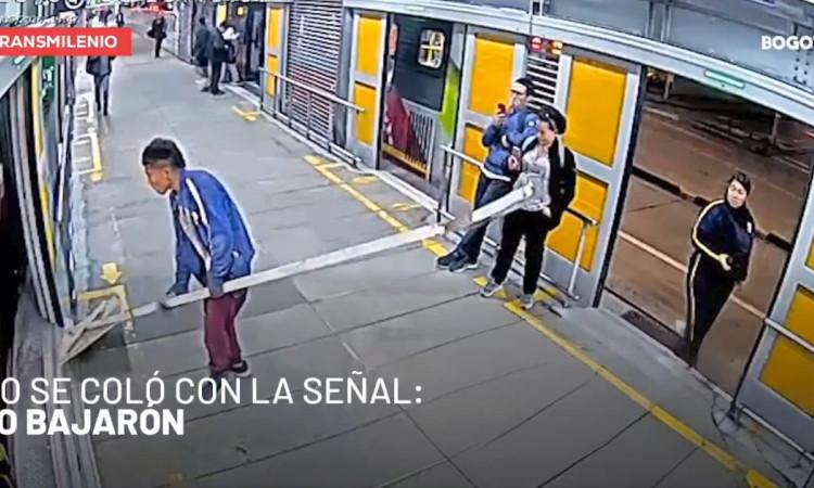 Imagen de cámara de seguridad en la que se ve a hombre intentando subirse a un bus de TransMilenio con una craga no permitida.