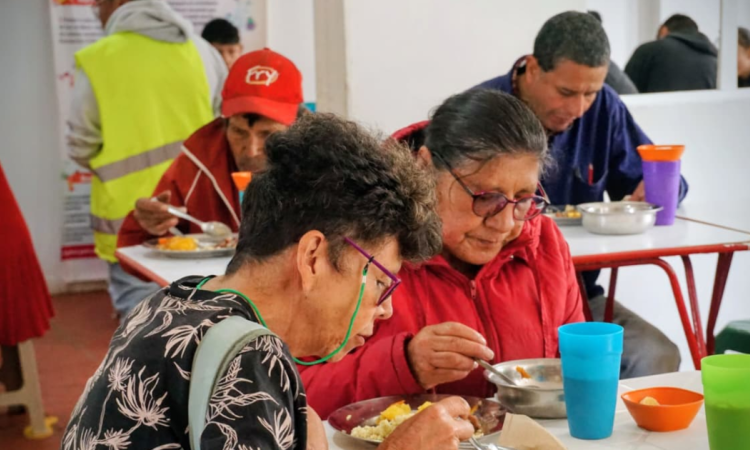Imagen de dos señoras comiendo un almuerzo en comedor comunitario