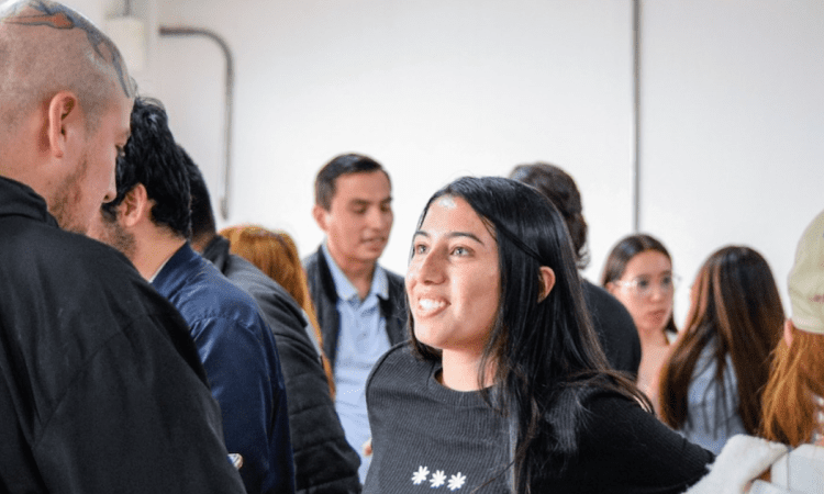 Imagen de una joven y un joven hablando y sonriendo