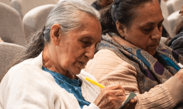 Imagen de dos señoras escribiendo en papeles