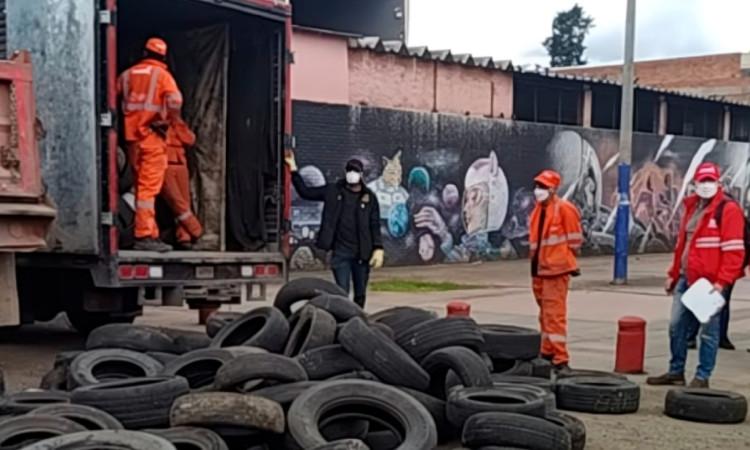 Foto que muestra llantas y personas limpiando 