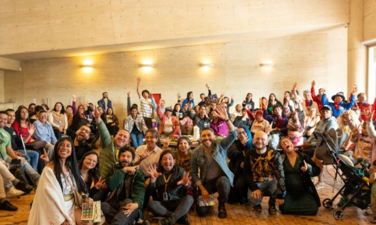 Imagen de grupo de personas con mano levantada de celebración en instalaciones de BibloRed