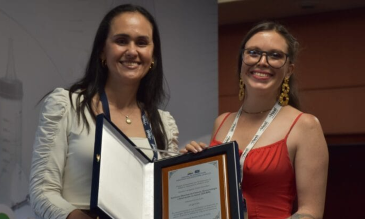 Foto de dos mujeres con un reconocimiento 