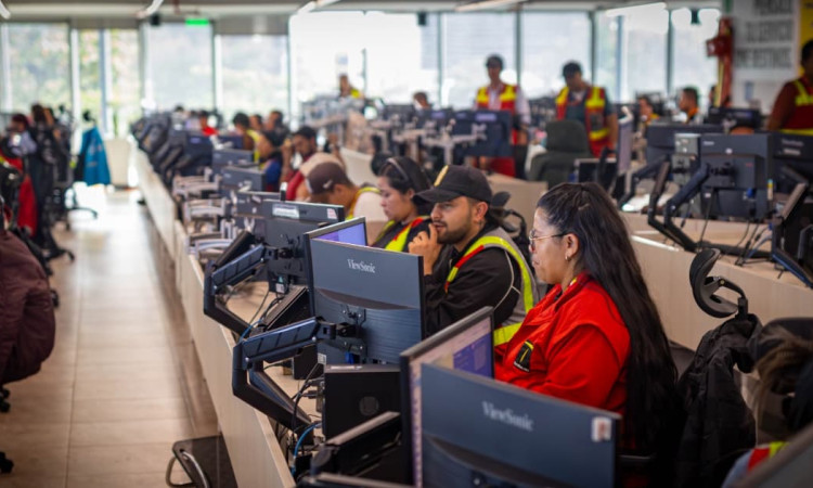 Funcionarios del Centro de Control de TransMilenio monitoreando desde computadores.