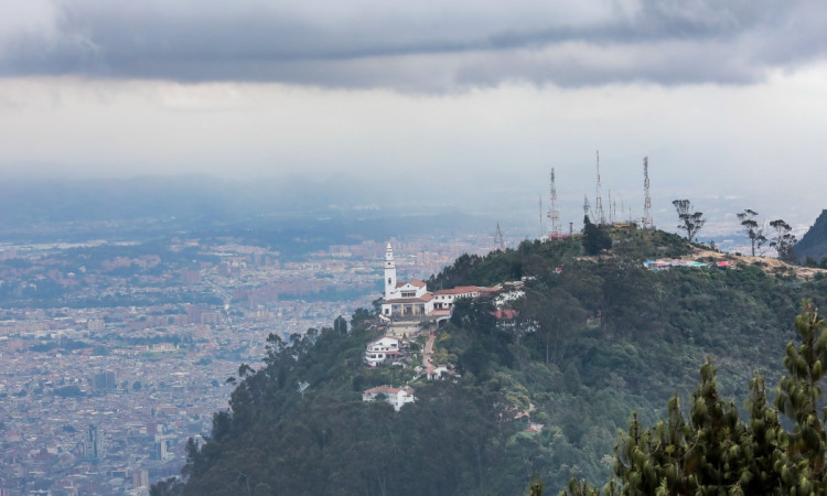 Foto pánoramica de Bogotá que muestra la iglesia de Monserrate, árboles y edificios 