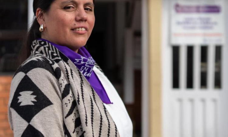Mujer con una pañoleta morada.