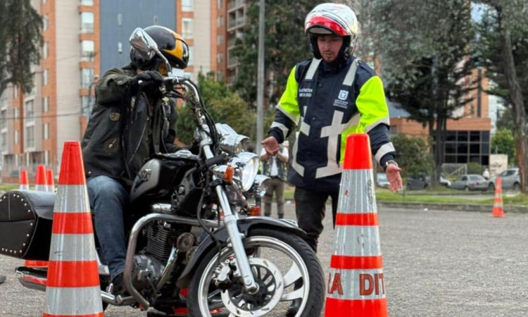 Foto de un motociclista y un funcionario de Movilidad 