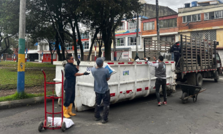 Foto que muestra personas colocando residuos en un ecopunto 