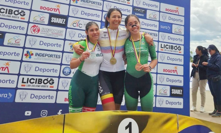 Atletas del Equipo Bogotá celebran en podio con medallas frente a panel del Campeonato Nacional de Paracycling Pista y Ruta