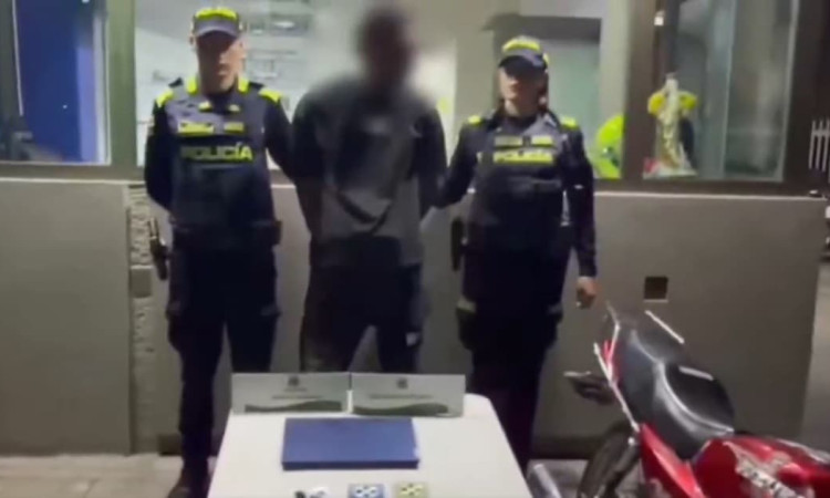 Foto de un delincuente capturado junto a dos uniformados.