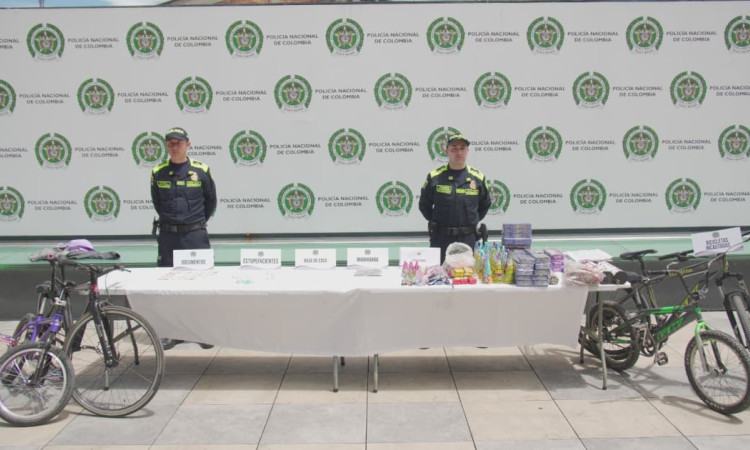 Uniformados de la Policía junto a mercancía incautada y bicicletas recuperadas.
