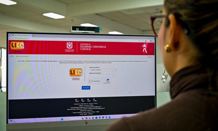 Mujer mirando a un computador, en cuya pantalla se ve la plataforma LICO.