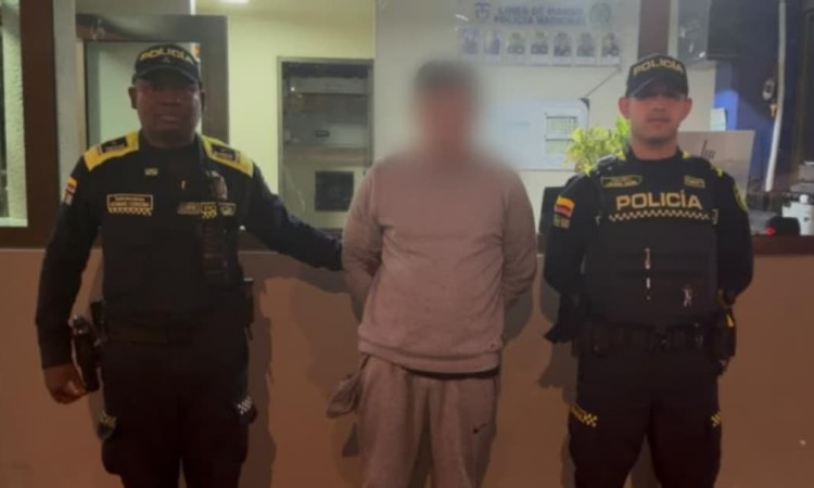 Hombre capturado en medio de dos policías en Bogotá.