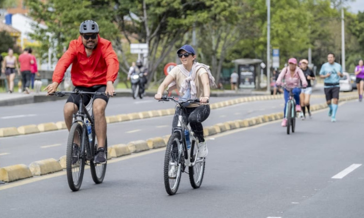 Personas en bicicleta recorren ciclovía urbana acompañadas por corredores y peatones Bogotá