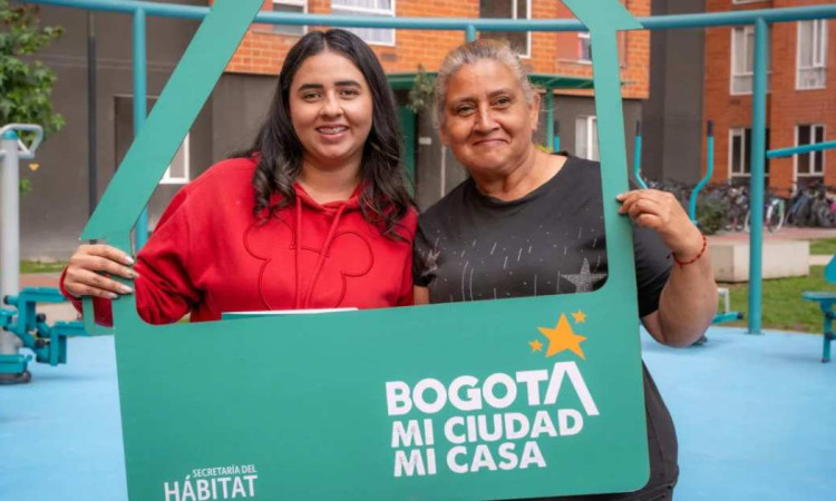 Foto que muestra dos mujeres sonriendo con un letrero que dice Bogotá mi ciudad mi casa