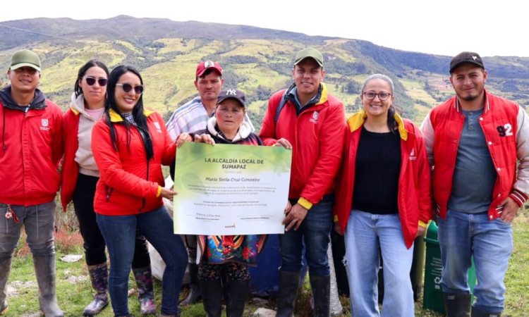 Funcionarios de la Alcaldía Local de Sumapaz con la comunidad mostrando un diploma de una firma simbólica de un acuerdo