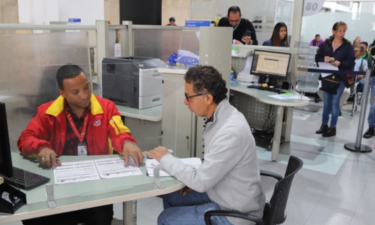 Ciudadano siendo atendido por un funcionario de la Secretaría de Hacienda