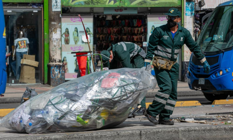 Imagen de Jorge cargando una bolsa de basura en una calle