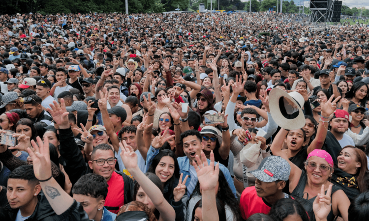 Multitud asiste a concierto masivo al aire libre en Bogotá con miles de asistentes reunidos frente al escenario principal.