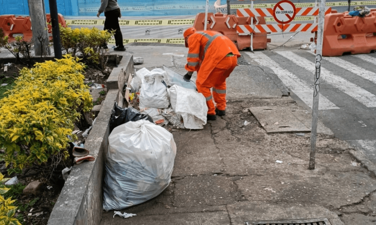 Foto que muestra personas limpiando una zona con basuras 