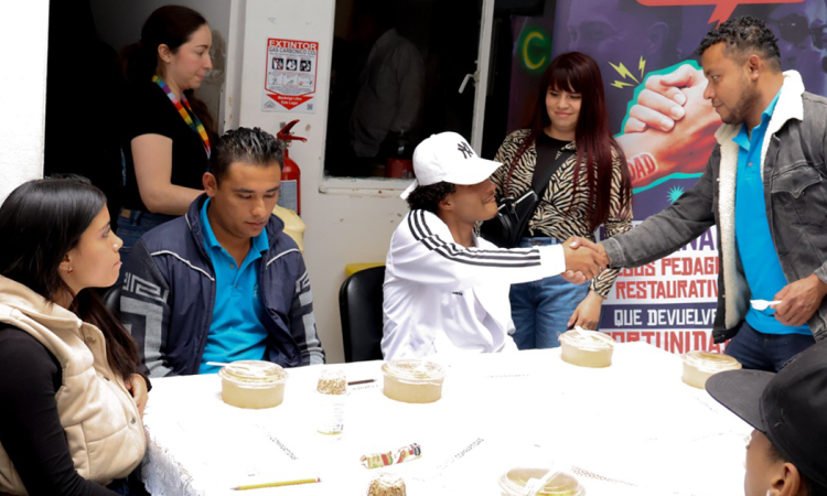 Imagen de varias personas hablando mientras comen