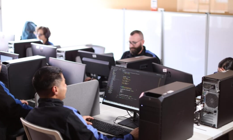 Foto que muestra personas trabajando frente a computadores 