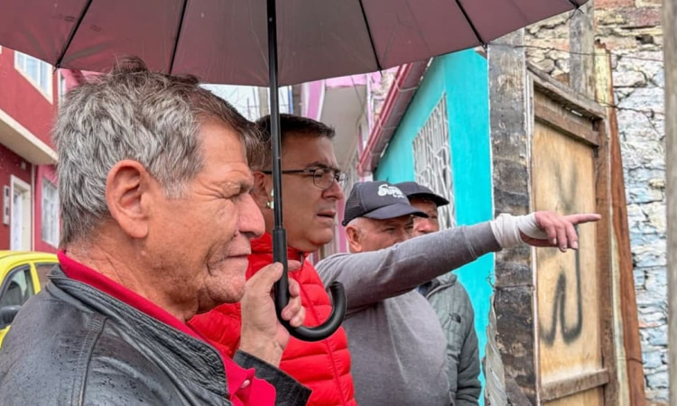 Personas participan en recorrido comunitario con el IDIGER bajo la lluvia durante jornada de diálogo sobre gestión del riesgo en Bogotá.