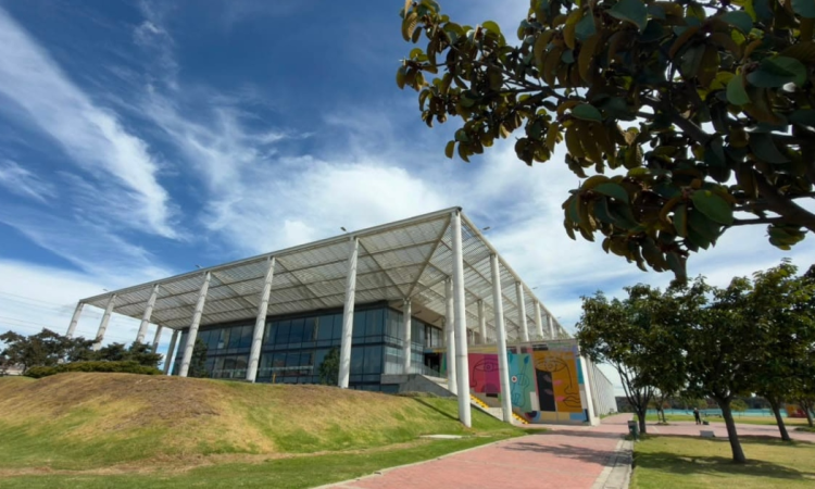 Foto que muestra un edificio con techo blanco y paredes en cristal 