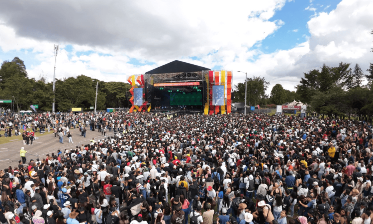 Miles de personas asisten al parque Simón Bolívar de Bogotá, reunidas frente a un escenario principal de gran formato durante un espectáculo musical al aire libre.