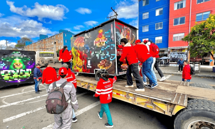 Foto que muestra un grupo de personas empujando un trailer de comidas