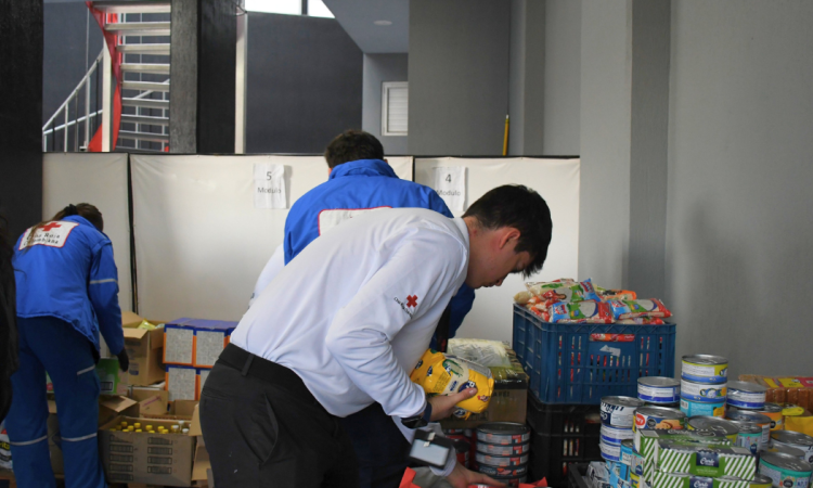 oto que muestra personas de la Cruz Roja organizando alimentos e insumos