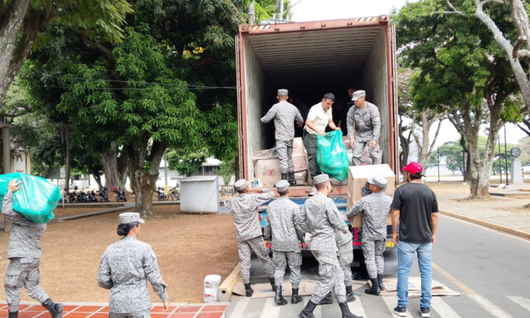 Foto de funcionarios e integrantes de las Fuerzas Armadas recibiendo ayudas en Cali.
