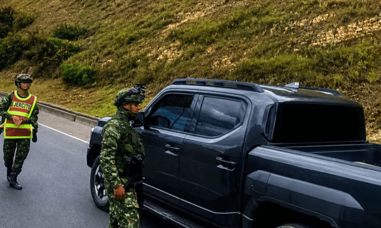 Uniformados del Ejército acercándose a una camioneta negra en una carretera.