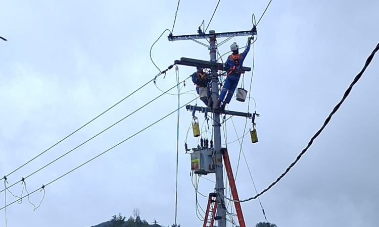 Foto que muestra dos personas con el uniforme de Enel Colombia trabajando en una antena de energía