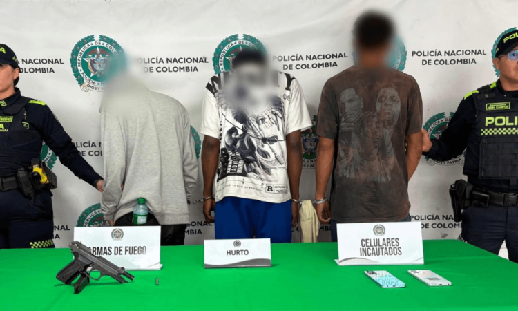 Tres hombres capturados, en medio de dos policías.