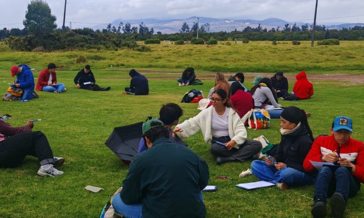 Personas sentadas en un parque analizando ¿Cómo queremos que sea Bogotá en 2038? 
