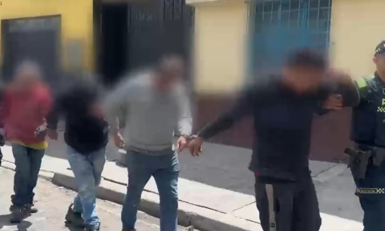Cuatro hombres capturados y esposados 