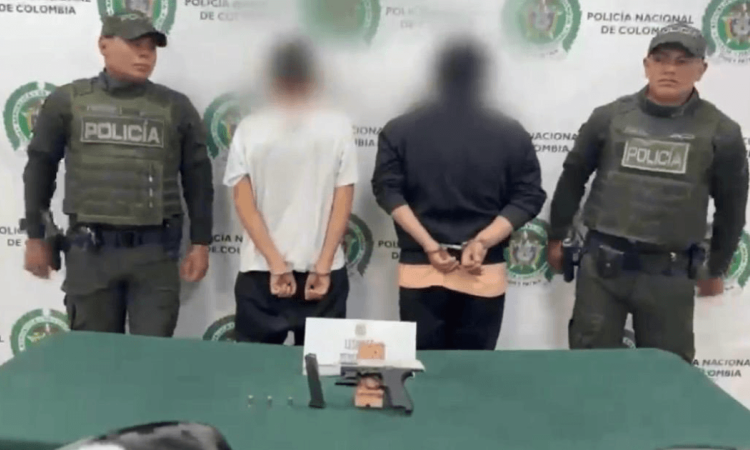 Dos hombres capturados, en medio de dos policías.