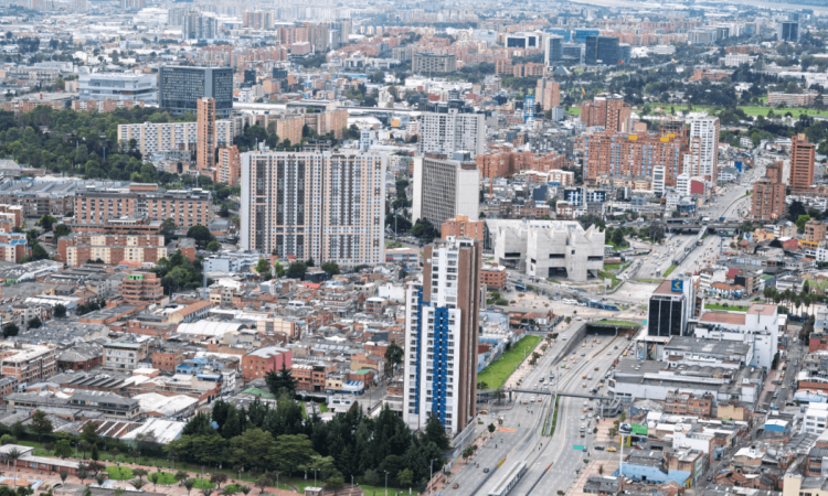 Vista aérea de Bogotá con edificios residenciales y comerciales, corredores viales de alta circulación y amplias zonas urbanas.