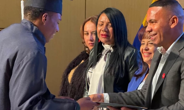 Un joven recibiendo su diploma de bachiller durante ceremonia en Bogotá.