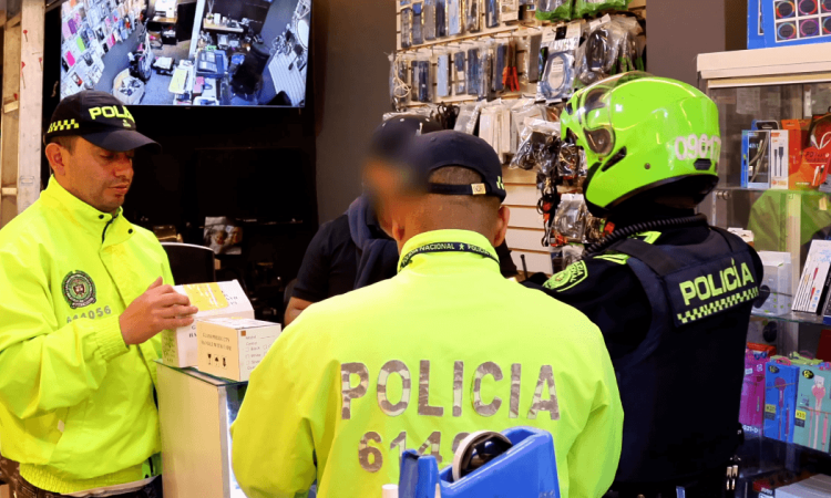 Policías inspeccionando establecimiento de venta de celulares.