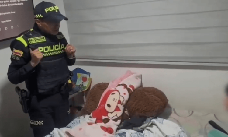 Uniformado de la policía frente a la niña rescatada.