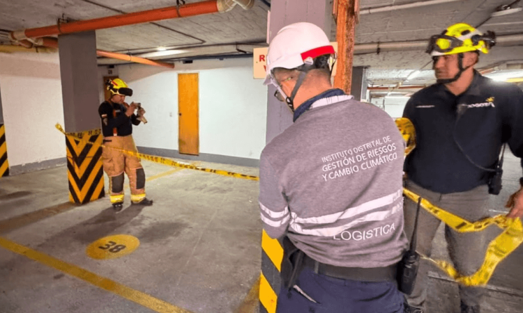 Foto que muestra tres personas con cascos revisando una pared 