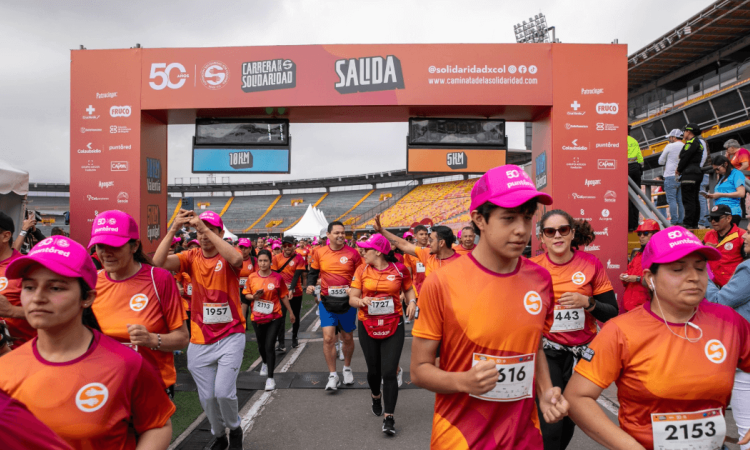 Participantes de la Carrera de la Solidaridad cruzan el punto de salida en el estadio El Campín.