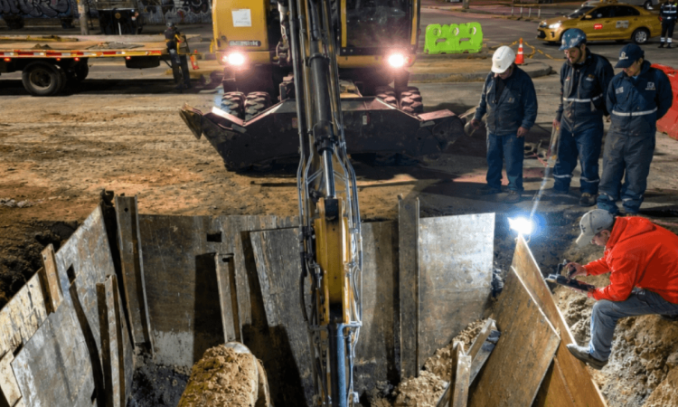 Foto que muestra un hueco en el piso y personas trabajando 