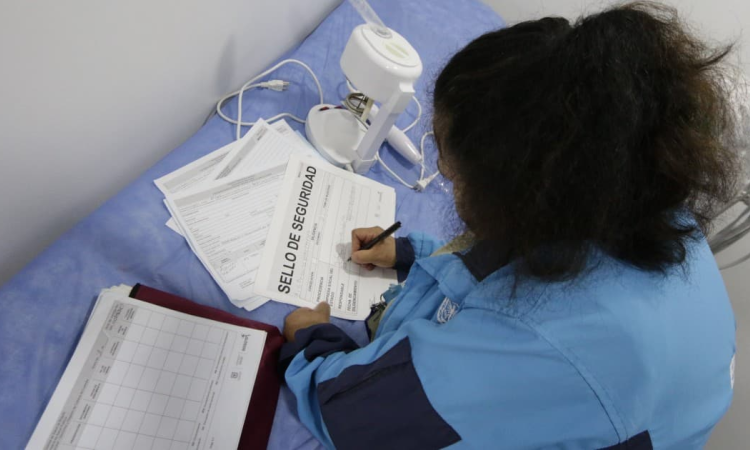 Foto de una persona firmando un papel