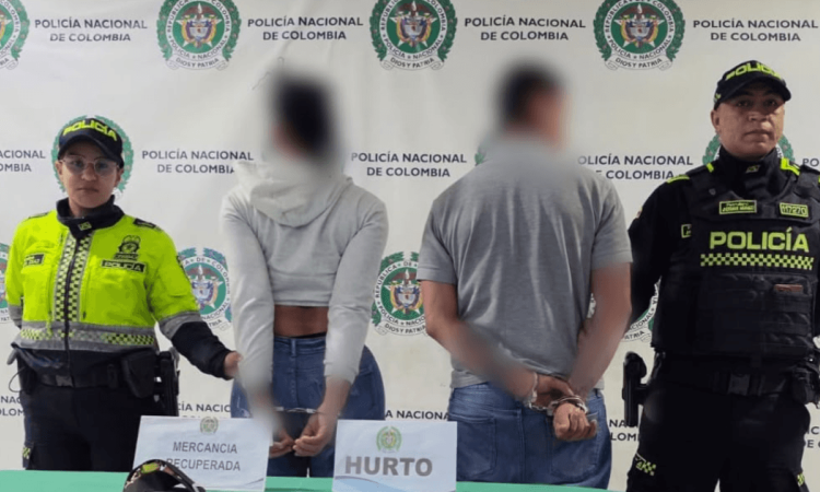 Un hombre y una mujer, capturados, en medio de dos policías.
