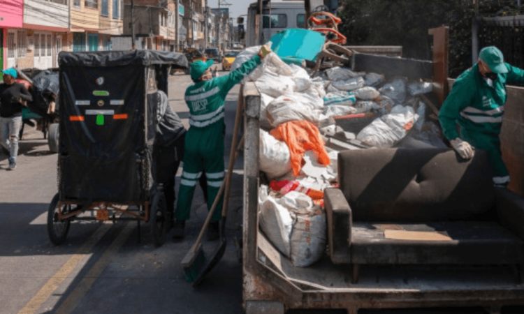 Foto que muestra personas colocando residuos en un ecopunto 